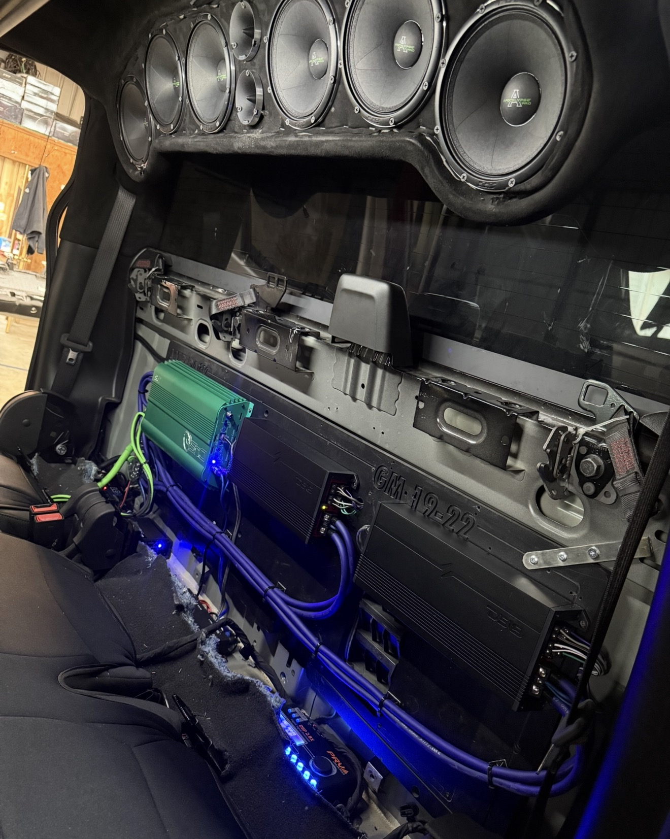 Finished truck overhead speaker rack with amps and blue-lit wiring