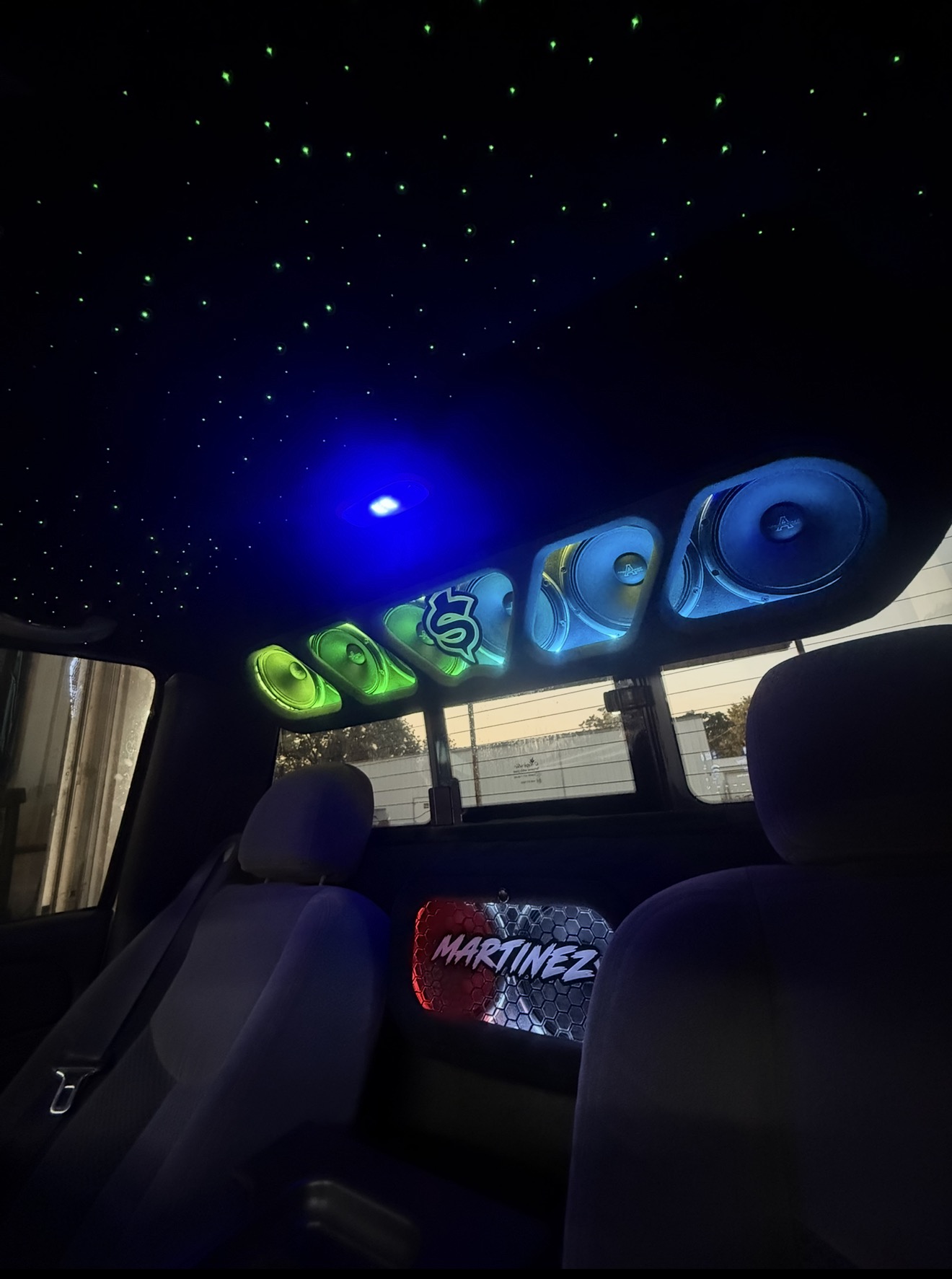 Truck cabin with green starlight headliner and multicolor overhead speaker pods