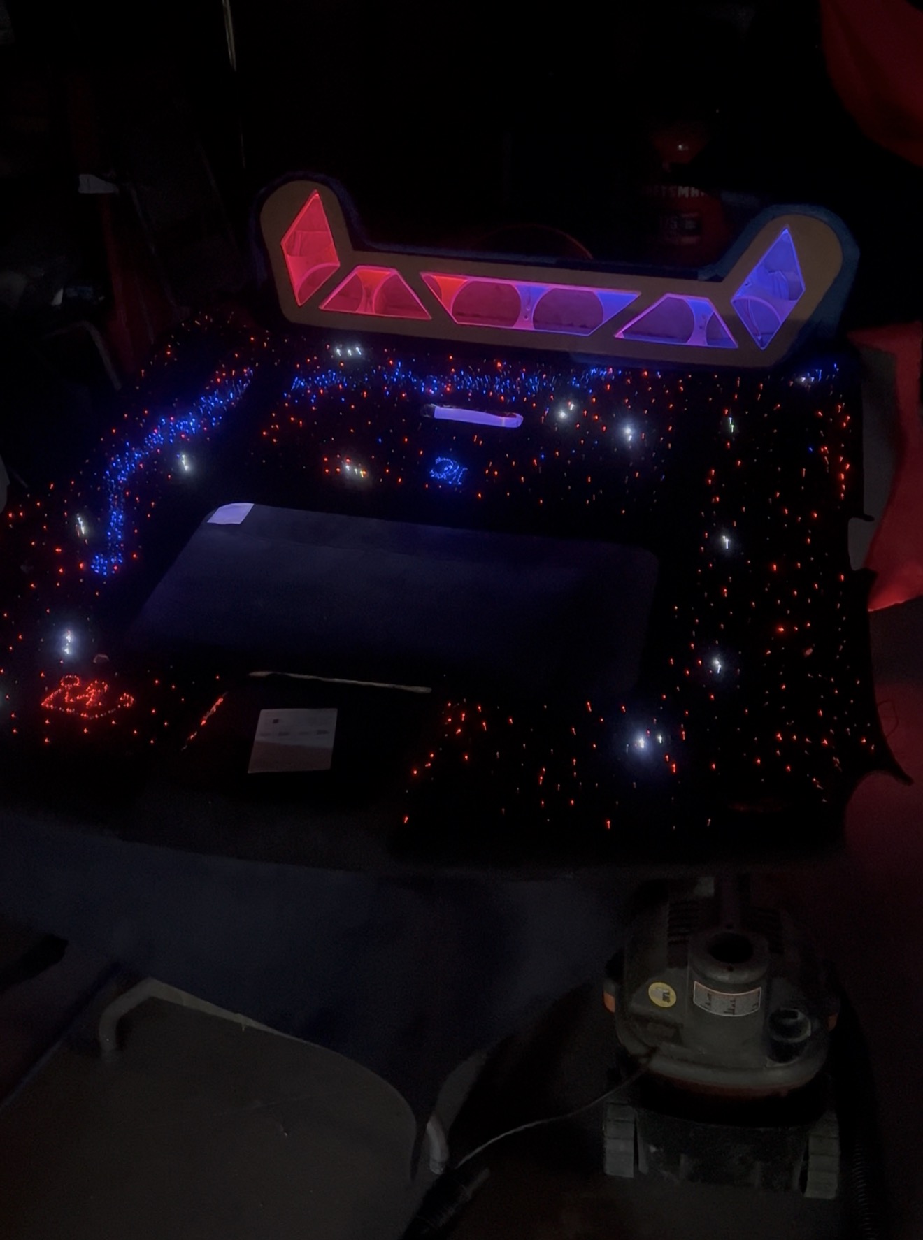 Fabricated overhead console with red and blue LED inserts on a starlight headliner in the shop