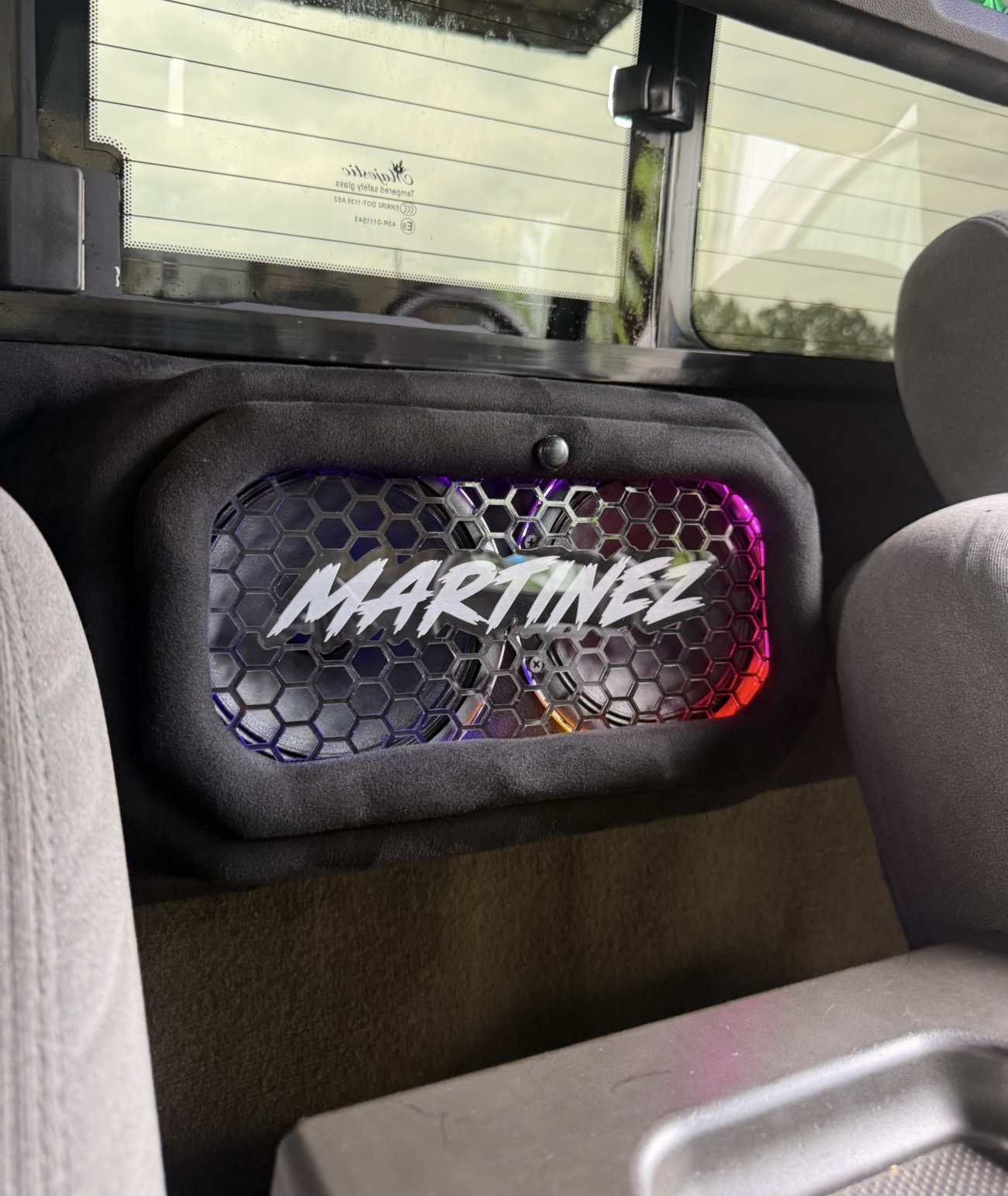 Custom suede door panel with honeycomb grille and RGB-lit Martinez name plate